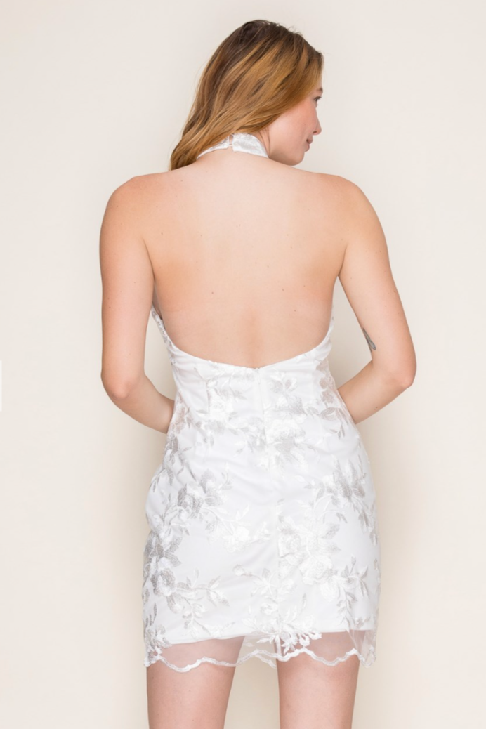 Woman wearing a white lace dress against a plain background